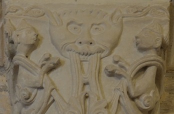 Chapiteau à masque démoniaque vomissant des rinceaux de feuillages